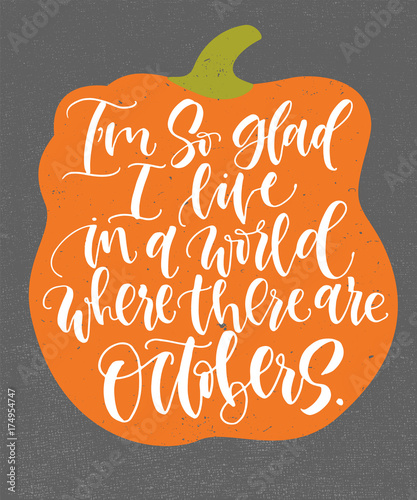 I'm so glad I live in a world where there are Octobers. Handwritten calligraphy quote and autumn motives with orange pumpkin on background. Poster or greeting card.