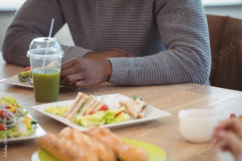 Mid section of businessman sitting at office cafeteria