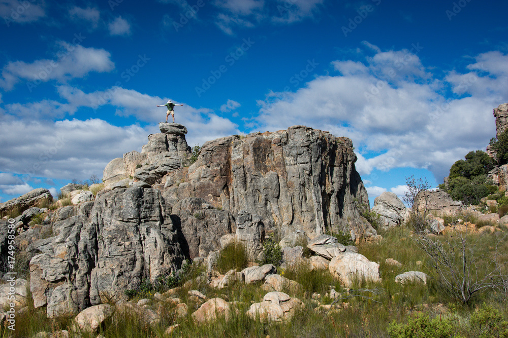 A hiker balances in the wind on top of a rock in the Cederberg Wilderness Area, South Africa A hiker balances in the wind on top of a rock in the Cederberg Wilderness Area, South Africa