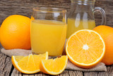 Orange juice in a glass and pitcher on table