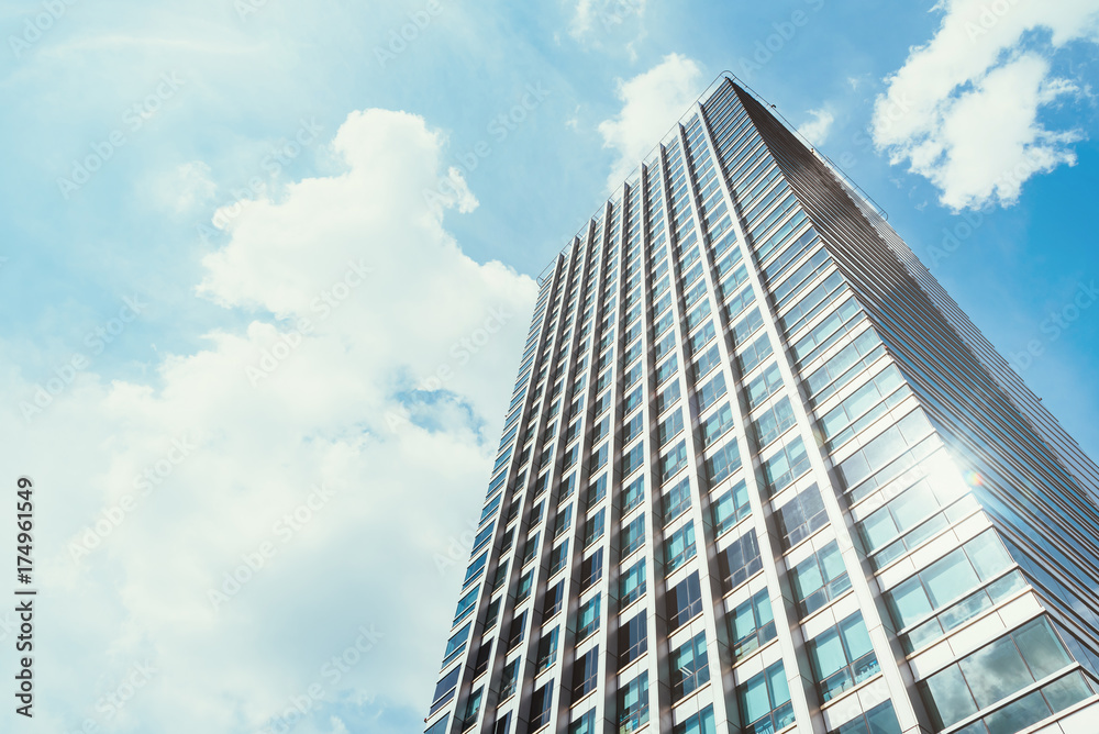 low angle view of office building with clear blue sky in background.