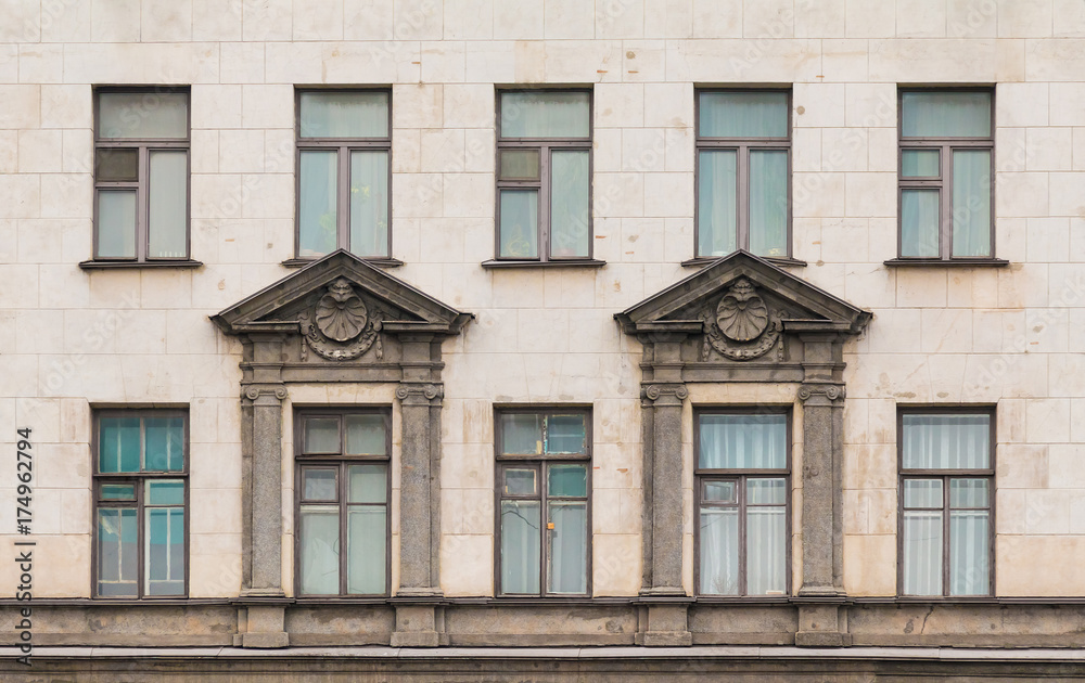 Several windows in a row on facade of urban apartment building front view, St. Petersburg, Russia