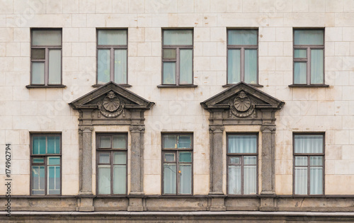 Several windows in a row on facade of urban apartment building front view, St. Petersburg, Russia