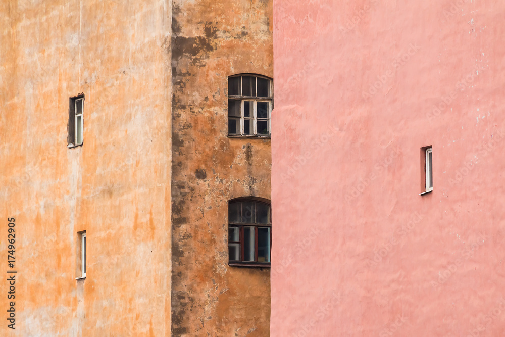 Several windows located on facades of two different urban apartment buildings chaotically, St. Petersburg, Russia