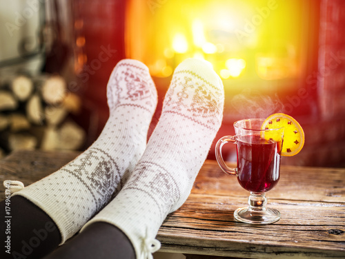 Fototapeta Naklejka Na Ścianę i Meble -  Warming and relaxing near fireplace with a cup of hot wine.