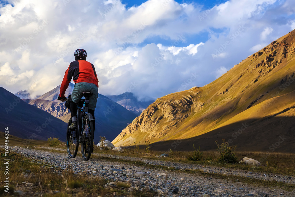 A man is riding a bicycle in the mountains. Autumn in the mountains.