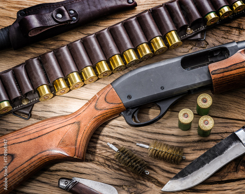 Pump action shotgun, 12 guage cartridge and hunting knife.