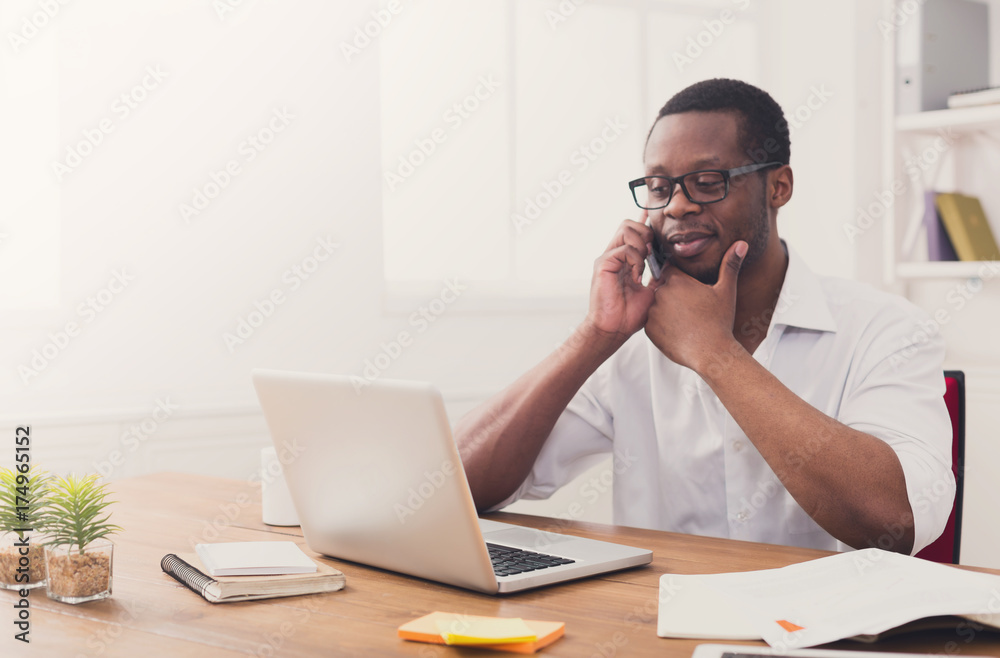 Young black businessman with mobile in modern white office Young black businessman with mobile in modern white office