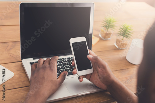African-american businessman in office type on laptop