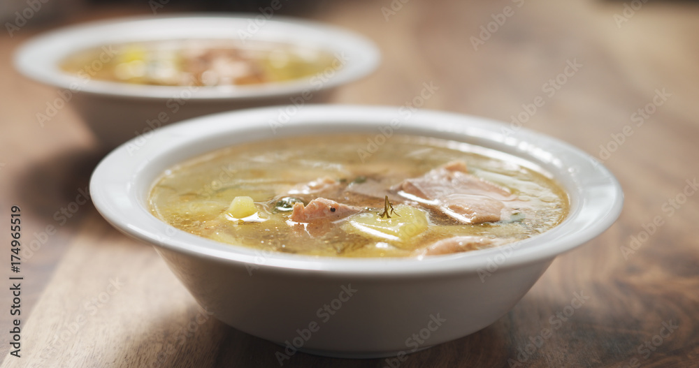 closeup fish soup with salmon on wood table