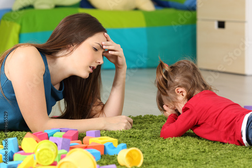 Angry baby and tired mother in a room