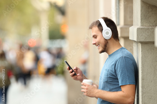 Profile of a guy listening music on line on the street