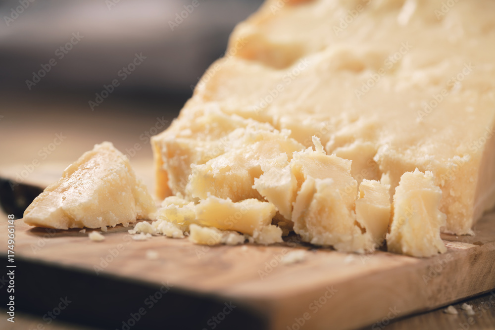 pieces of hard parmesan cheese on olive board pieces of hard parmesan cheese on olive board