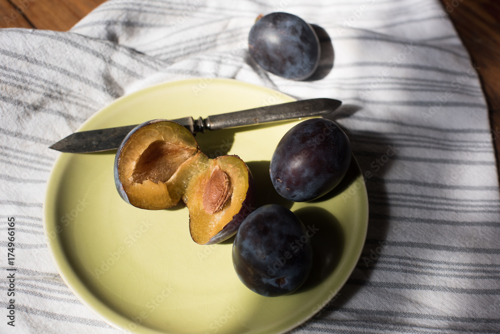 Wild purple plum's on green plate with vintage knife. Wild purple plum's on green plate with vintage knife.