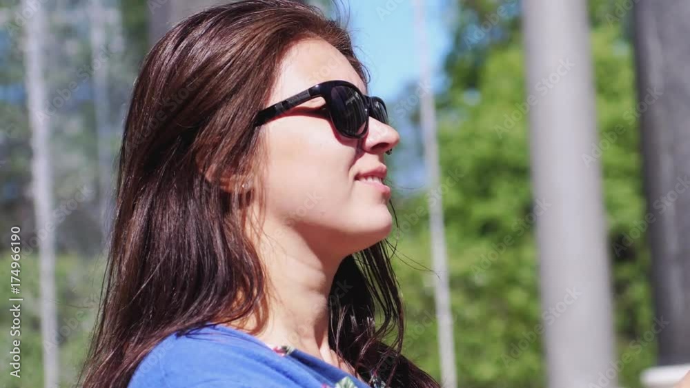 Beautiful brunette happy woman in sunglasses enjoying the sunlight smiles on nature in slow motion. 1920x1080 Beautiful brunette happy woman in sunglasses enjoying the sunlight smiles on nature in slow motion. 1920x1080