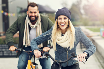 Young couple riding bikes and having fun in the city