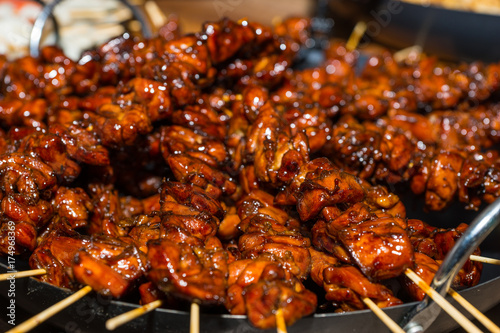 Appetizing roasted or barbecued marinated meat on skewers after hot grill at food festival