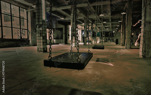 фотографія Swings in an abandoned old gloomy building with breakaway tiles on the walls