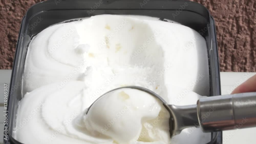 Lemon ice-cream (sorbet) being scooped out of container by a metal spoon. 4k Lemon ice-cream (sorbet) being scooped out of container by a metal spoon. 4k