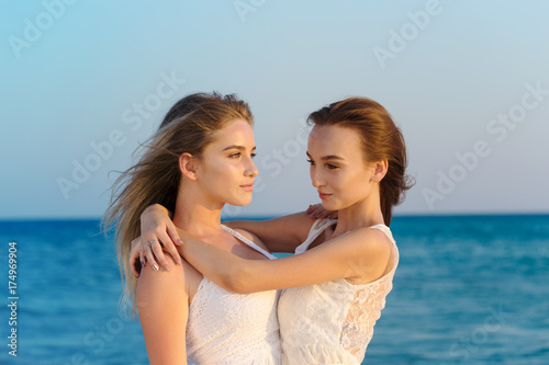 Two women in a white dress on beach