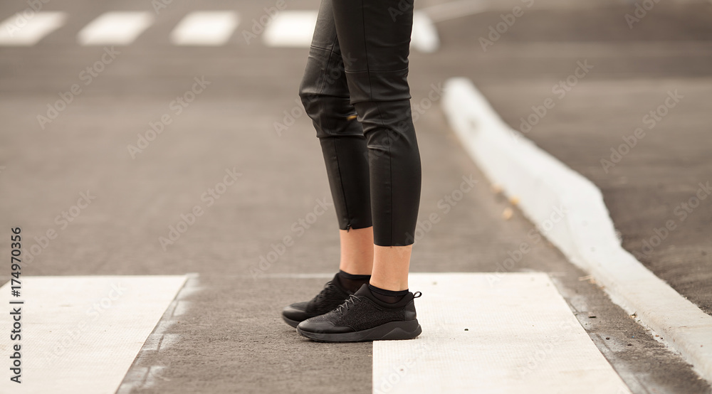 young woman crossing a street in the city on sunny summer day young woman crossing a street in the city on sunny summer day