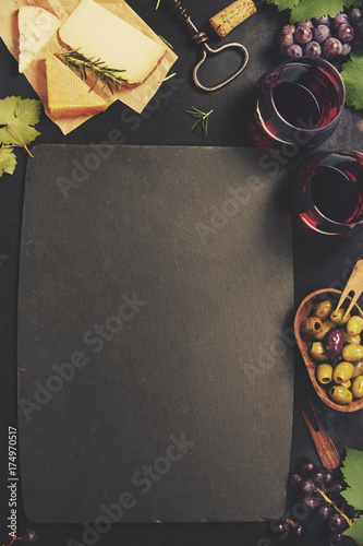 Wine appetizers set: French cheese selection, grapes and walnuts on rustic background