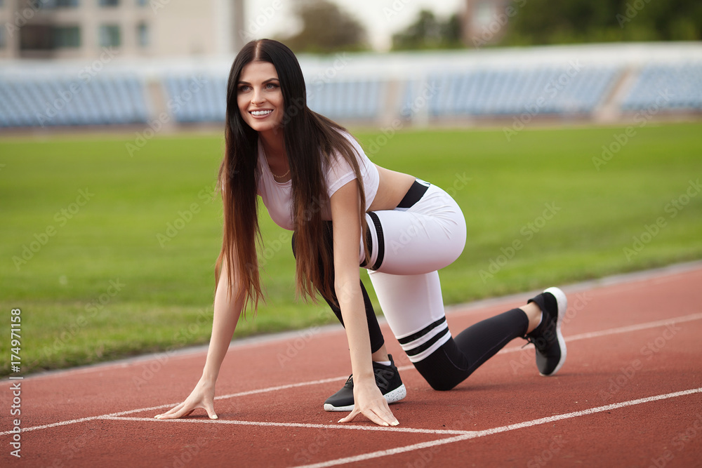 Fototapeta premium young fitness woman runner running on stadium track