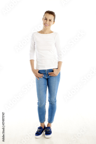 Full length shot of smiling young woman standing against white background