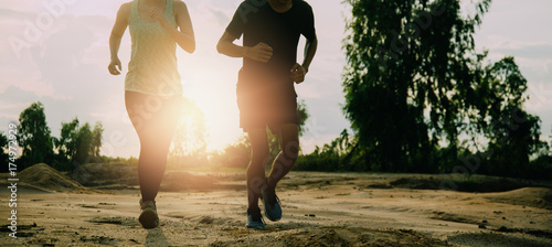 Bilde på lerret Man and women run in tropical garden at sunset.