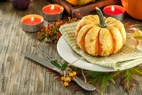 Autumn table setting with pumpkings and candles, fall home decoration for festive dinner