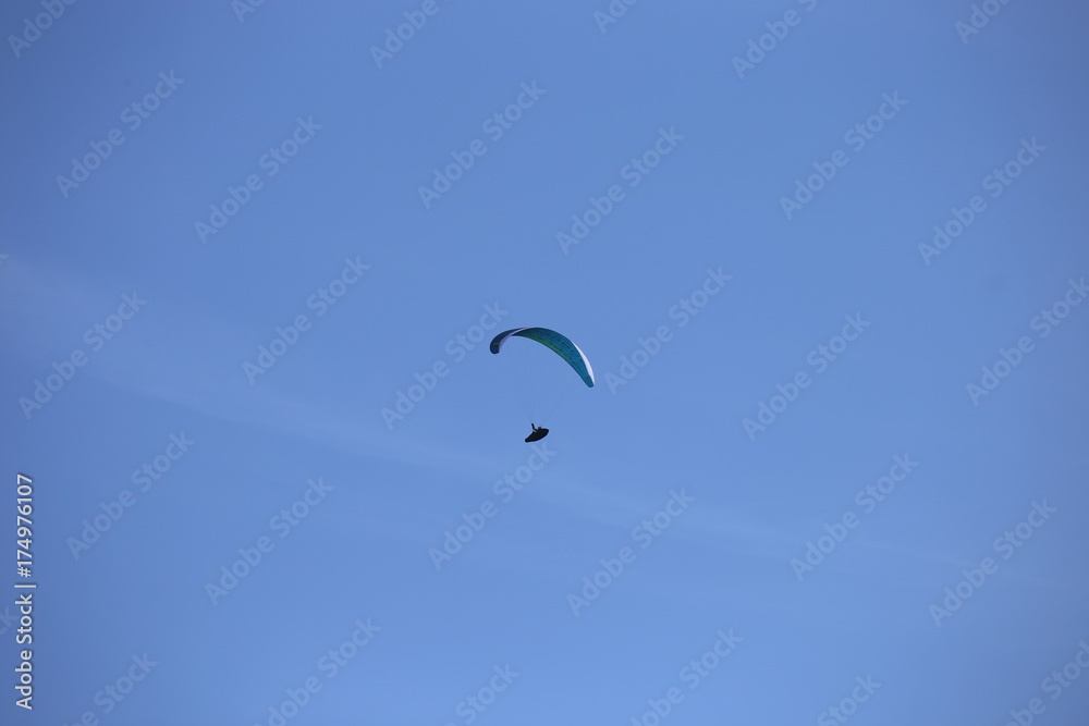 Gleitschirmflieger (Paraglider) vor blauem Himmel
