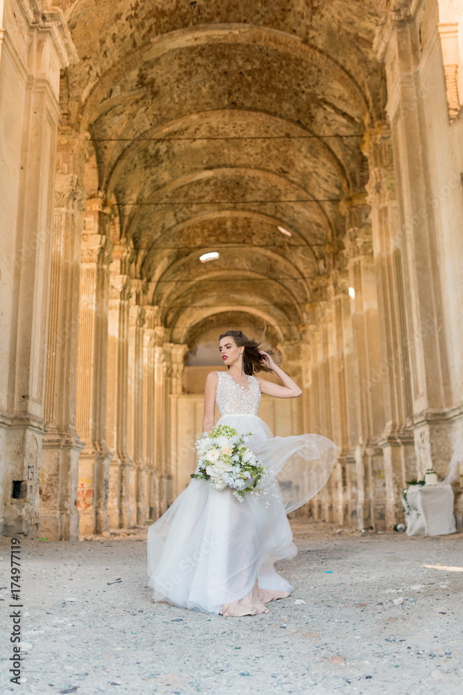 Romantic beautiful bride in luxury dress posing of beautiful architecture Romantic beautiful bride in luxury dress posing of beautiful architecture