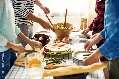 Fotografia Mid-section group of young people preparing dinner for festive celebration stand