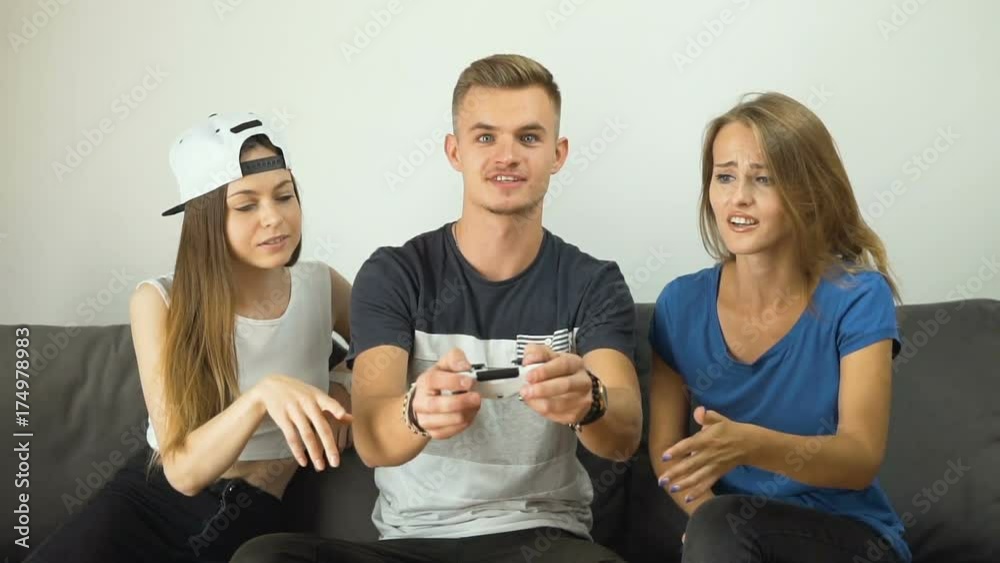 Gripped caucasian teens playing a video game on the comfortable sofa, slow motion Gripped caucasian teens playing a video game on the comfortable sofa, slow motion
