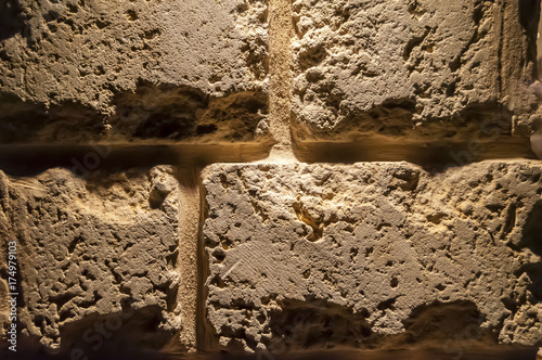 Old brown brick wall background illuminated.