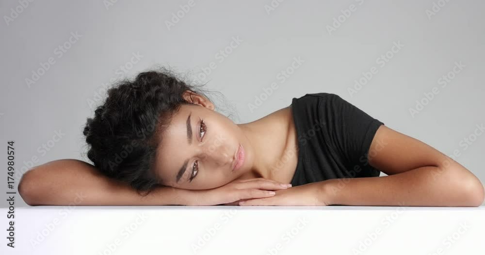 Cute teenage eastern girl with beautiful eyes and smile resting her head on her hands looking relaxed Cute teenage eastern girl with beautiful eyes and smile resting her head on her hands looking relaxed