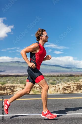 Bild auf Leinwand Triathlon runner triathlete man running in tri suit at ironman competition race on road
