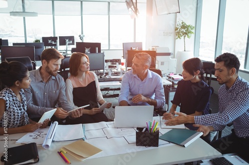 High angle view of creative business colleagues discussing photo