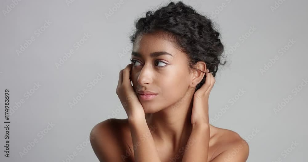 Head and shoulders shot of a naked young female model with gorgeous smooth skin isolated on white