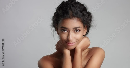 Head and shoulders shot of a naked young female model with gorgeous smooth skin isolated on white