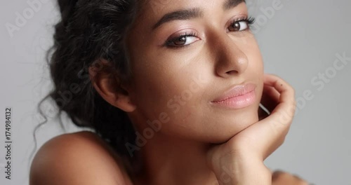 Portrait shot of a pretty olive-skinned model with brown eyes, black hair and beautiful smile on white background