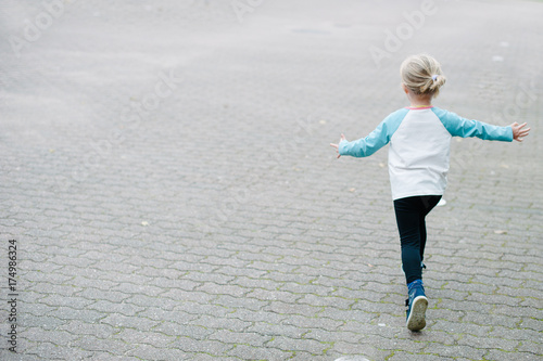 Little child running away. Back view.