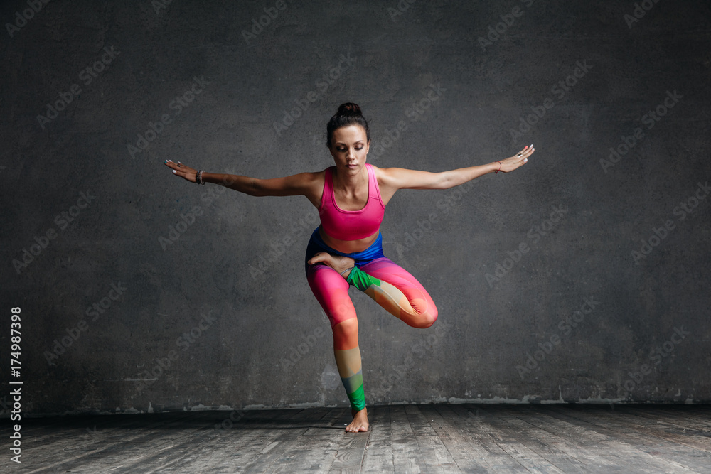 Young beautiful yoga female posing in studio