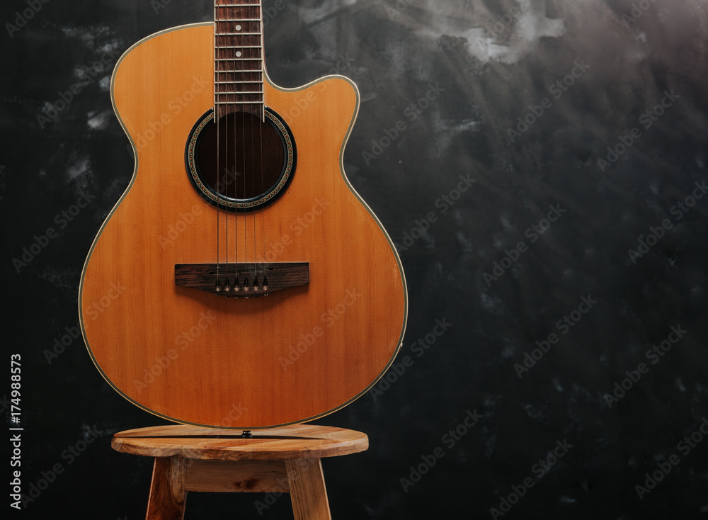 Fototapeta premium guitar on chair and black background.