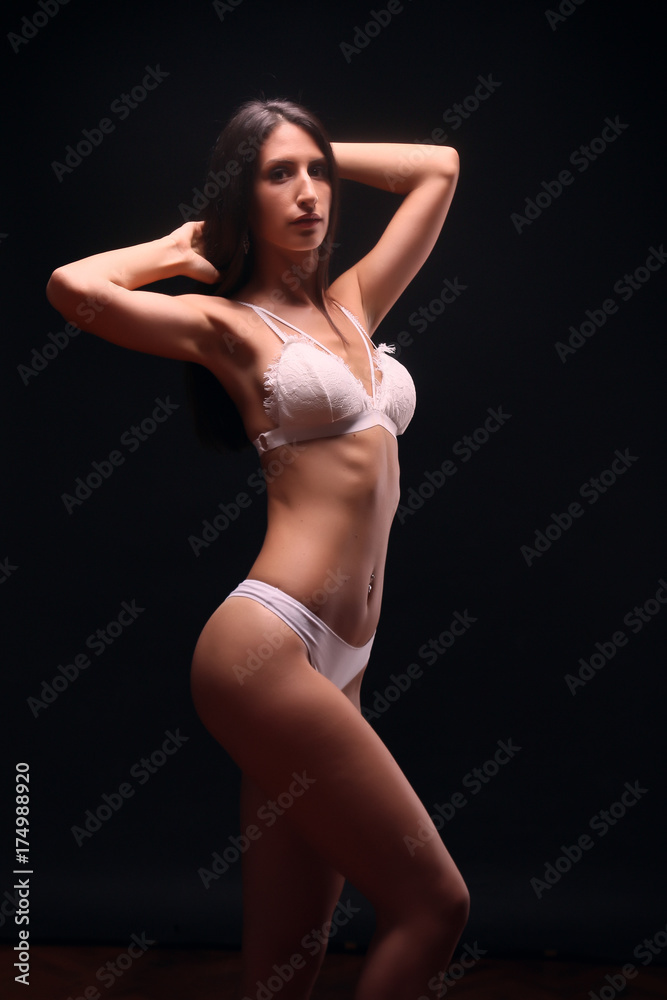 one young adult woman, standing model posing, black hair, white lingerie, white bra, white undergarment,