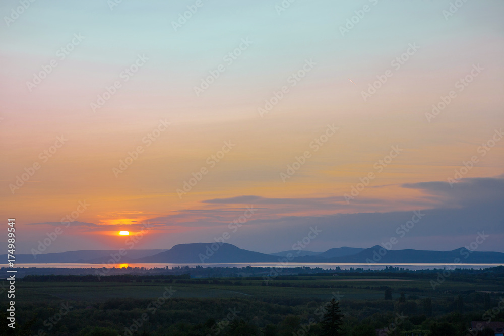 Colorful sunset with the Lake Balaton and the Badacsony mountain in the background