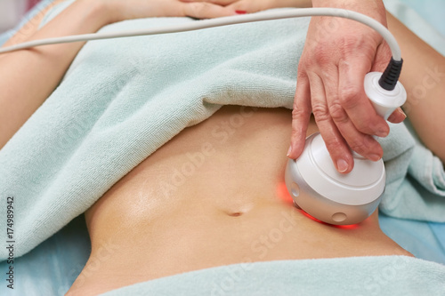 Rf skin tightening, belly. Hand of cosmetician, female body. Non surgical body sculpting.