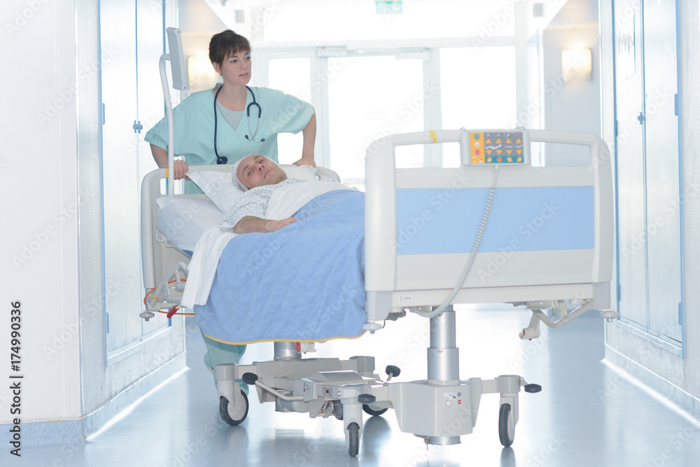 Obraz premium Nurse pushing patient in his bed