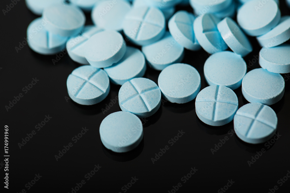blue pills scattered on the table. blue pills scattered on the table.
