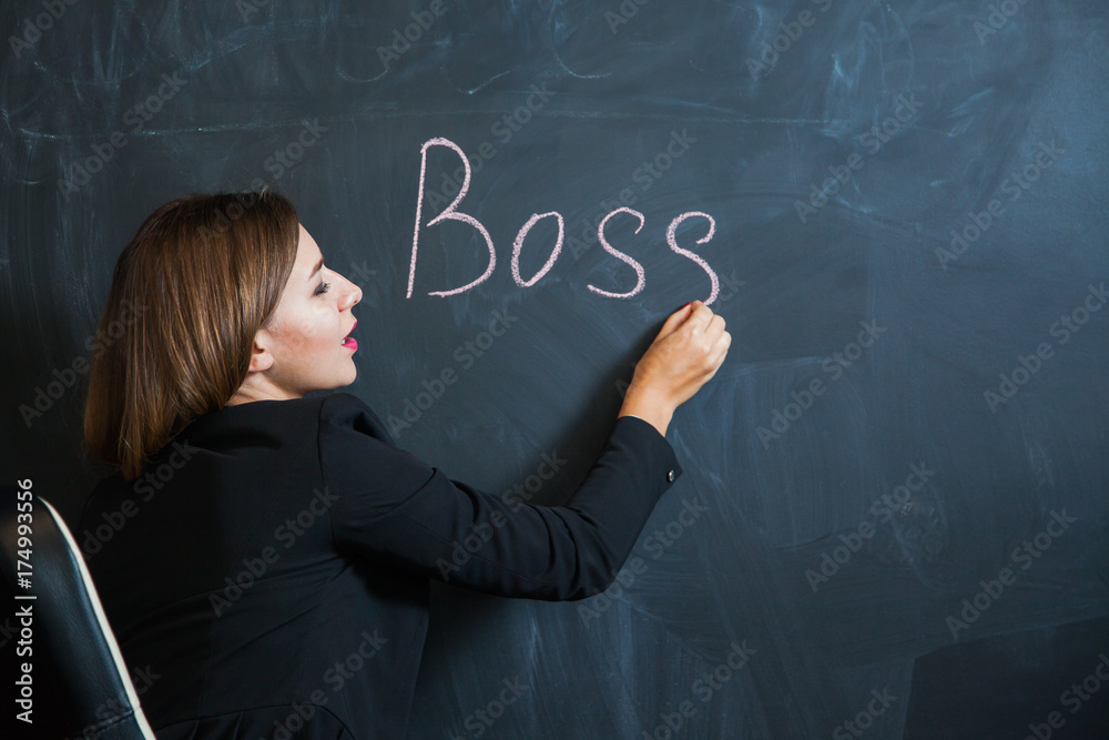 Business woman writing the word boss on desk